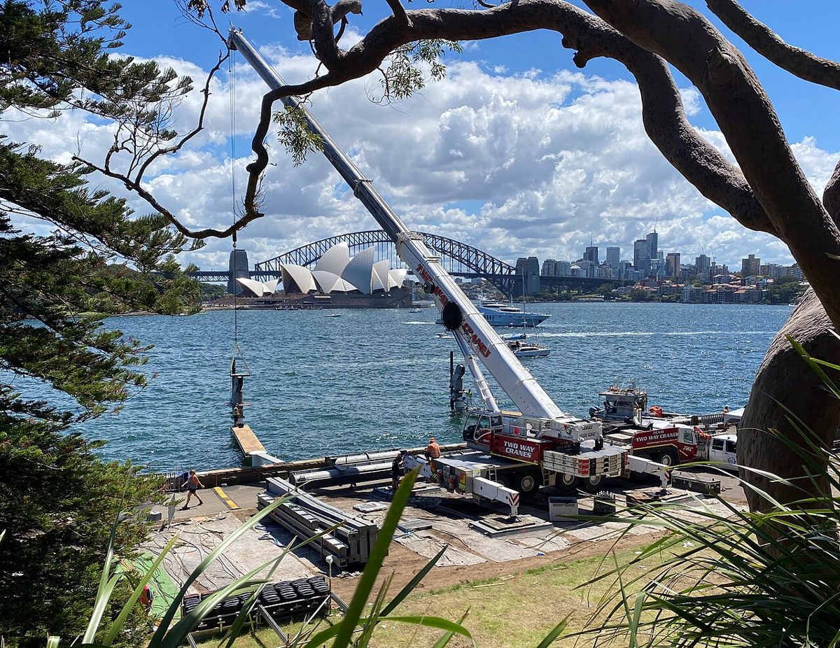 Crane crew working on Sydney Harbour, Opera House behind
